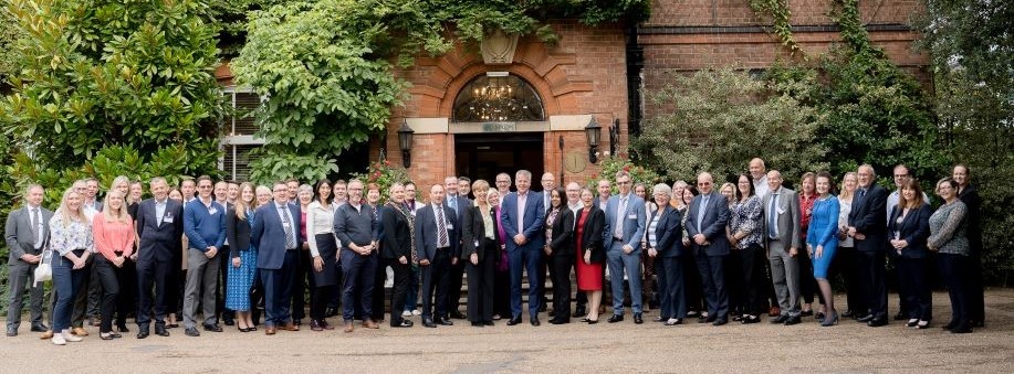 Participants of the AFEP CFO retreat 2023 standing in front of the Ardencote Manor Hotel entrance. THey are all smartly dresse and facing the camera for a group photo after another successful CFO retreat.